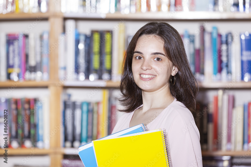 Female student holding books at the university library Female student holding books at the university library