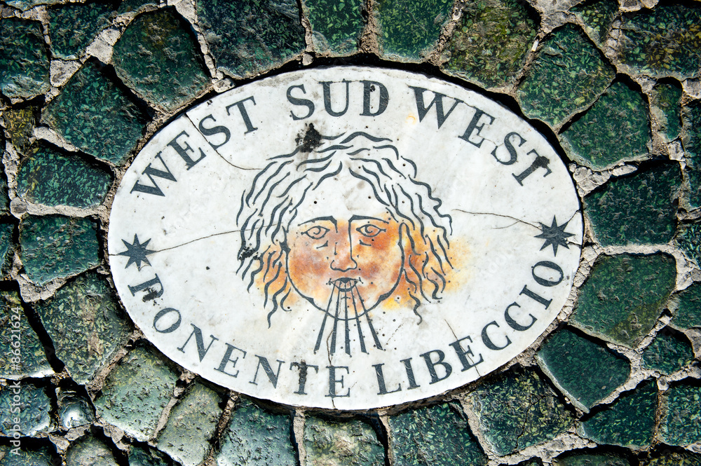 Old wind marker on cobblestone pavement Old wind marker on cobblestone pavement