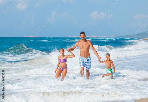 Father and children playing on the beach
