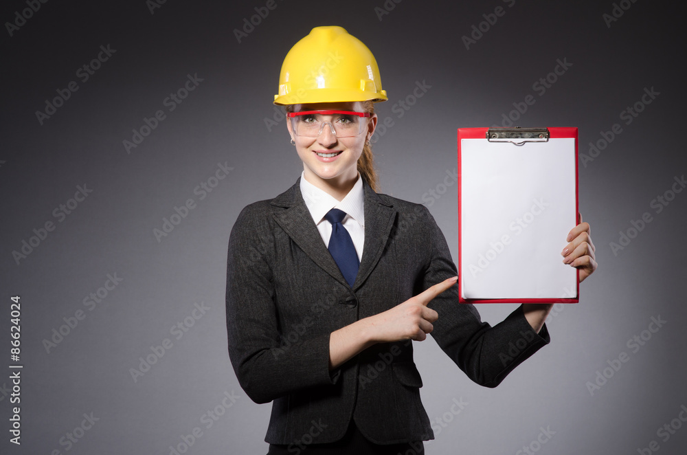 Female engineer with helmet isolated on gray Female engineer with helmet isolated on gray