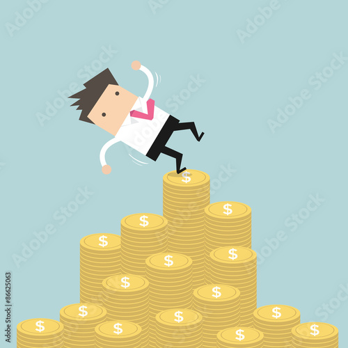 Businessman falling of money mountain