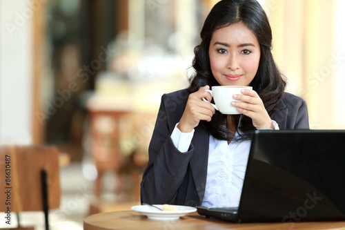 businesswoman doing her work while taking a coffee break