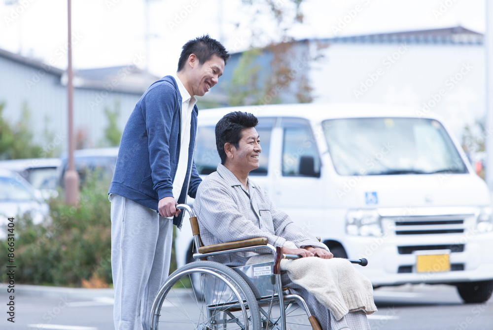 車椅子の男性と男性介護士