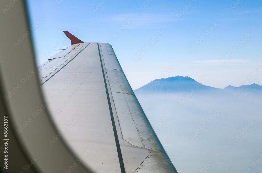 view of mountain peaks and wings of the aircraft from inside