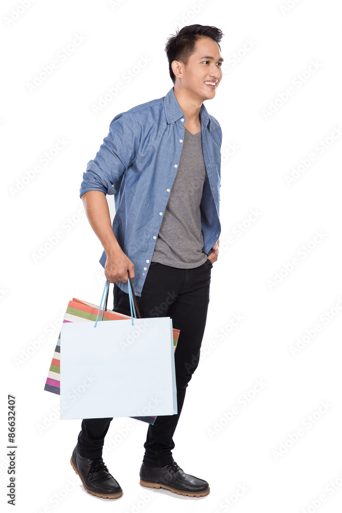 Young asian man walking and holding shopping bags, full body Young asian man walking and holding shopping bags, full body