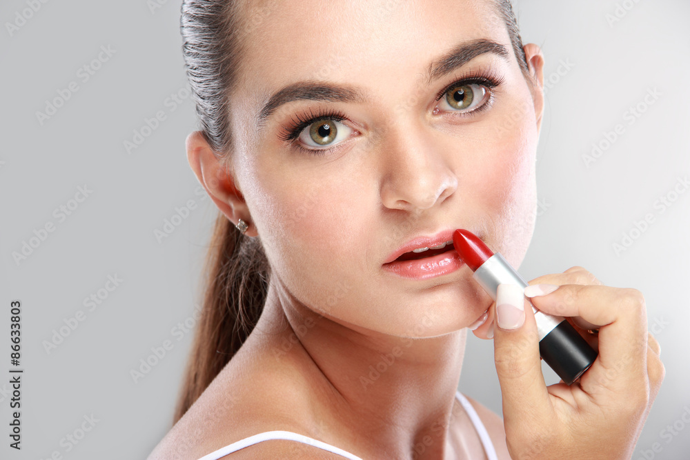 beautiful young woman applying lipstick beautiful young woman applying lipstick