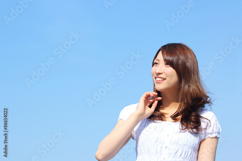 young asian woman looking up at the sky