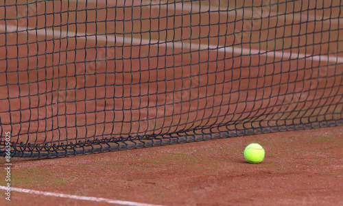 Tennis ball on the orange tenniscourt
