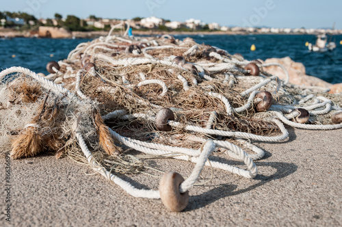 Redes de pesca sobre el muelle con el mar al fondo photo