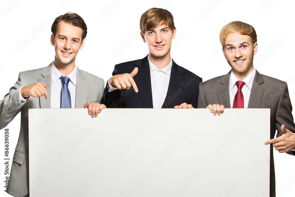 three businessmen holding and pointing at white board three businessmen holding and pointing at white board