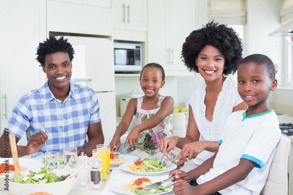 Happy family sitting down to dinner together Happy family sitting down to dinner together