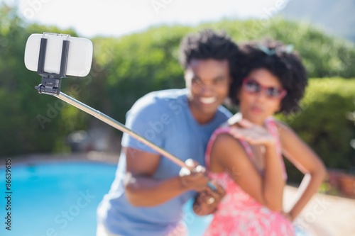 Happy couple using a selfie stick © WavebreakmediaMicro