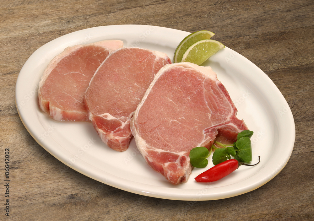 Raw meat selection on wooden cutting board with knife Raw meat selection on wooden cutting board with knife