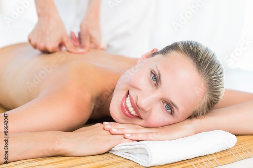 Pretty blonde enjoying a massage smiling at camera
