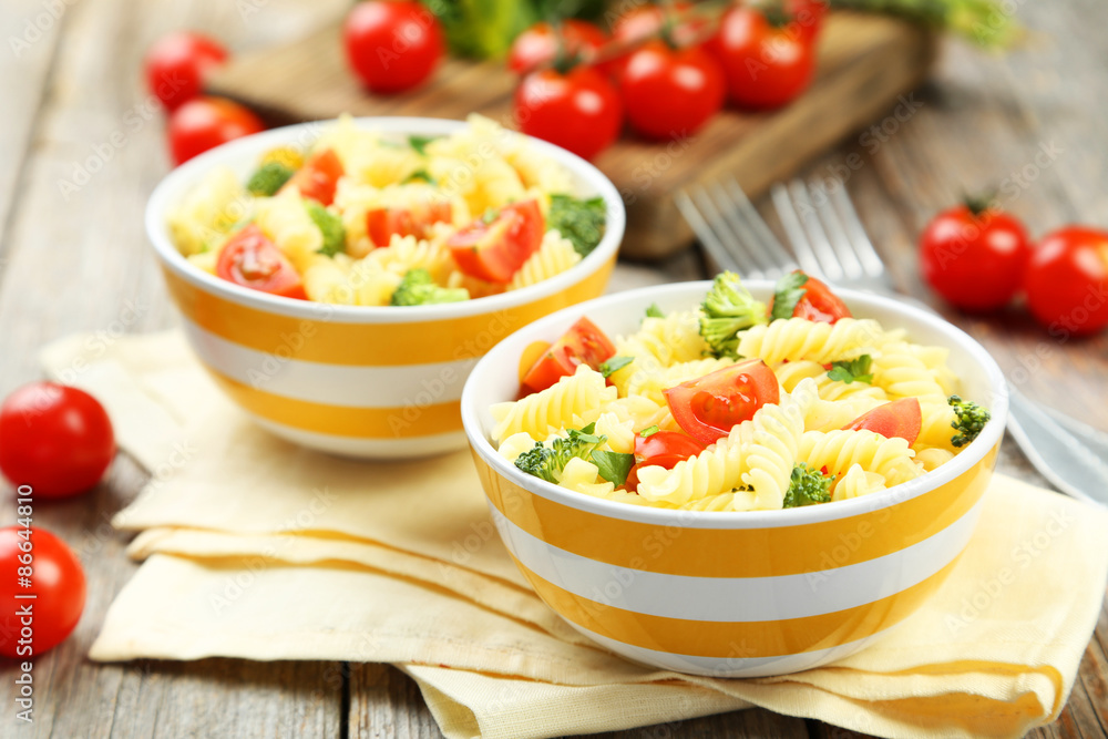 Delicious pasta in bowl on grey wooden background Delicious pasta in bowl on grey wooden background