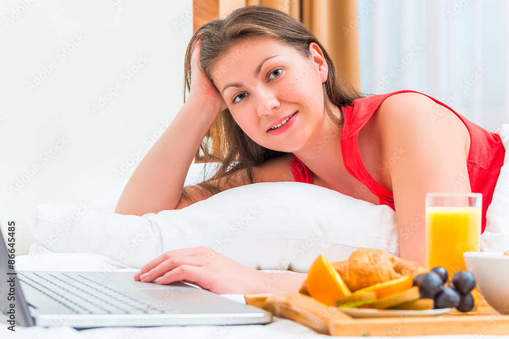 girl of European appearance with a laptop in bed girl of European appearance with a laptop in bed