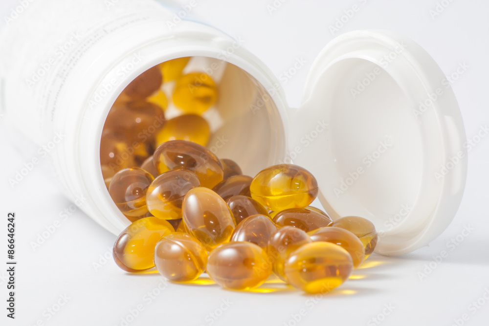 Close up gold capsule on white background selective focus Close up gold capsule on white background selective focus