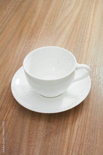 Empty white cup on wood background
