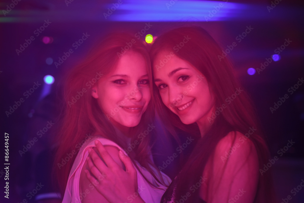 Two girls smiling in a disco pub Two girls smiling in a disco pub