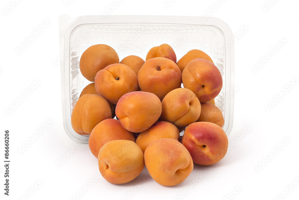 Box or punnet and spilled fresh ripe organic apricots isolated on white background Box or punnet and spilled fresh ripe organic apricots isolated on white background