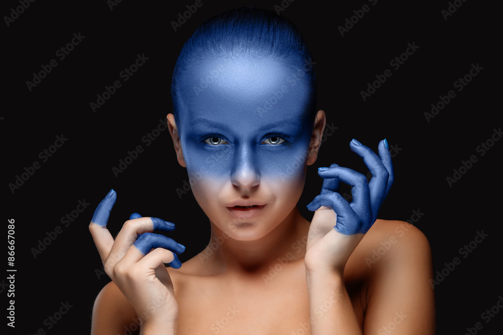 Fototapeta premium Portrait of a woman who is posing covered with blue paint