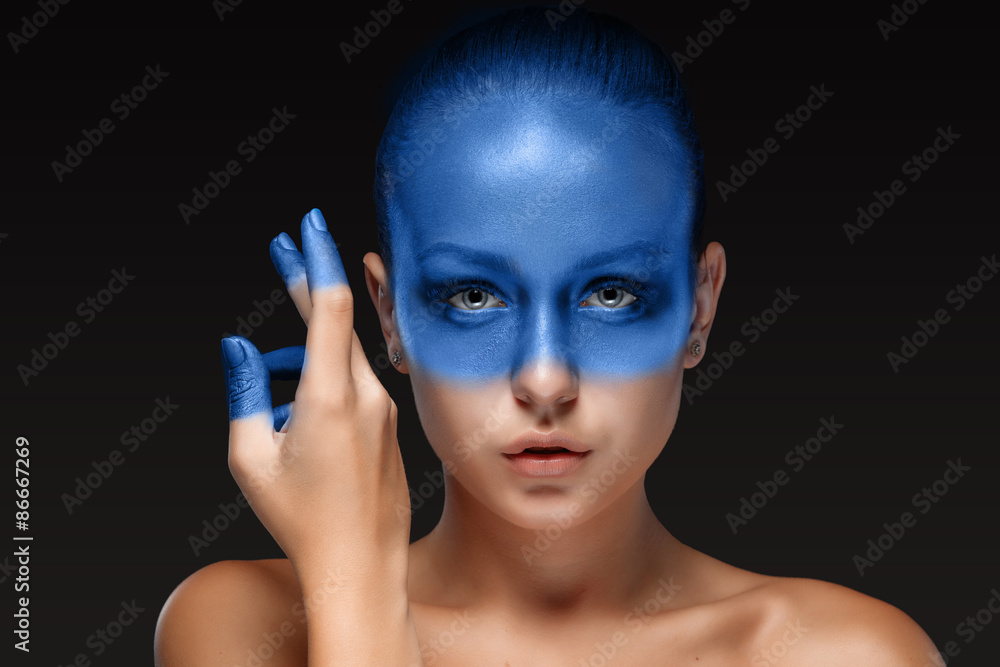 Fototapeta premium Portrait of a woman who is posing covered with blue paint