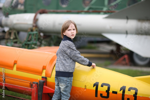 Sceptical face of an elementary-aged boy examining a vintage aircraft photo