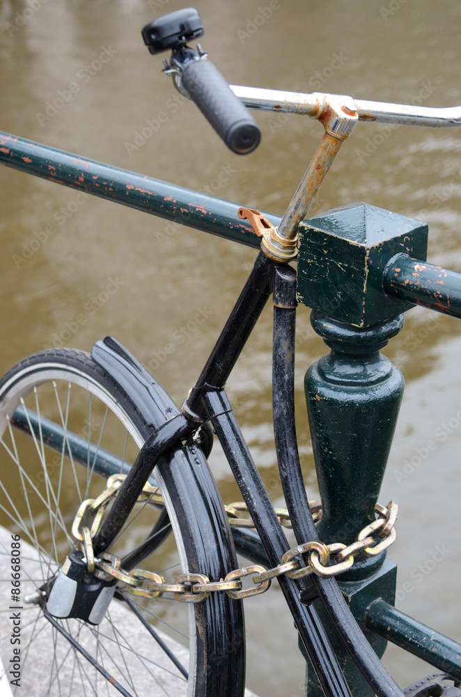 Fragment bike close-up metallic chain attached to railings in Am Fragment bike close-up metallic chain attached to railings in Am