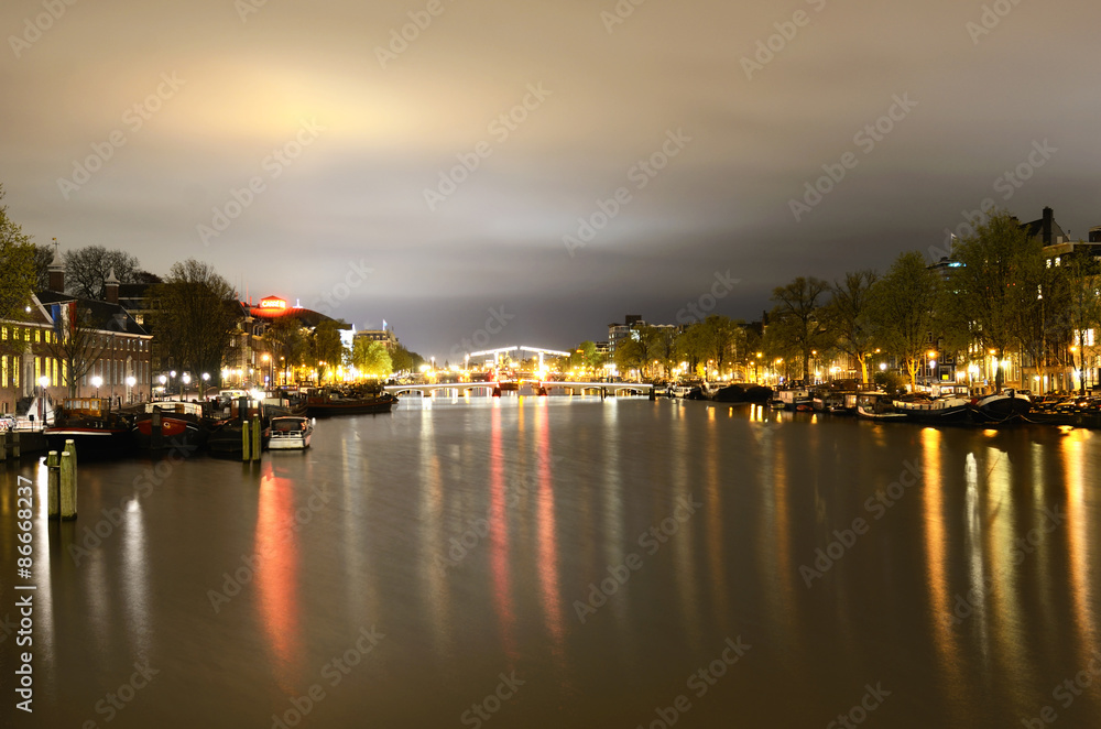 Fototapeta premium View of the night channel bridge in illumination and boats in Am