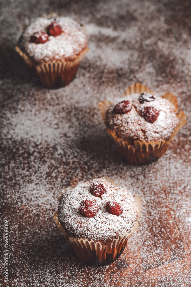 Muffins on a wooden table covered with sugar.
Muffins on a wooden table covered with sugar.