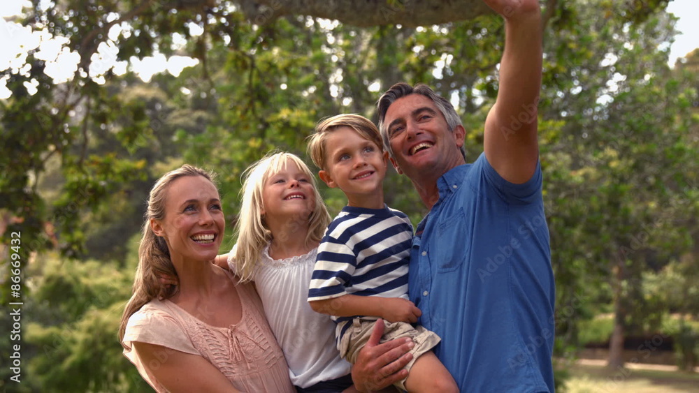 Happy family taking a selfie in the park Happy family taking a selfie in the park