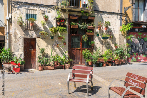 With flowers, plants and flowerpots decorated house in the Barcelona district La Ribera. Some beautiful spaces and places in the narrow neighborhood in the Barcelona district La Ribera