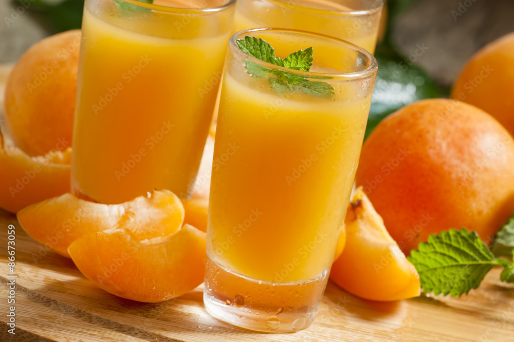Fresh apricot juice and apricots with mint on wooden board, sele Fresh apricot juice and apricots with mint on wooden board, sele