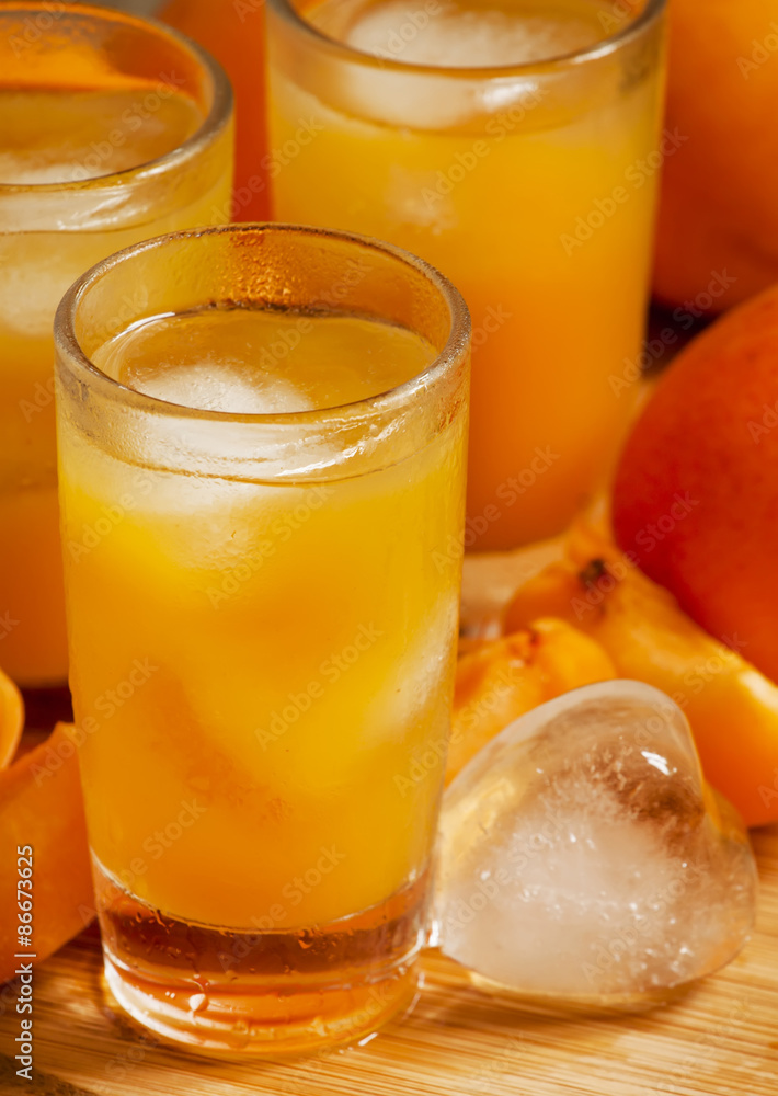 Freshly squeezed apricot juice with ice, selective focus Freshly squeezed apricot juice with ice, selective focus
