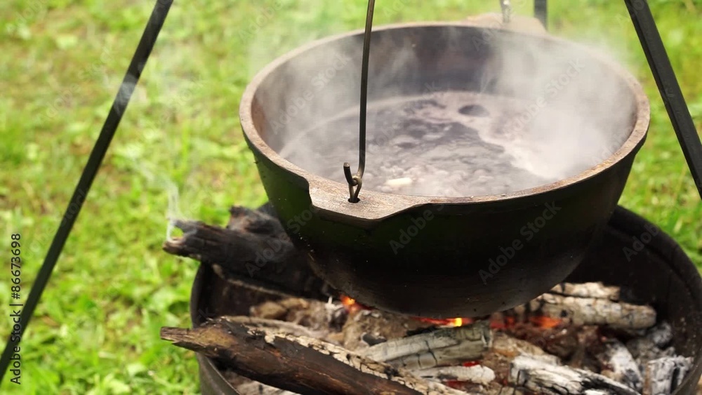 Cooking soup in metal pan on campfire Cooking soup in metal pan on campfire