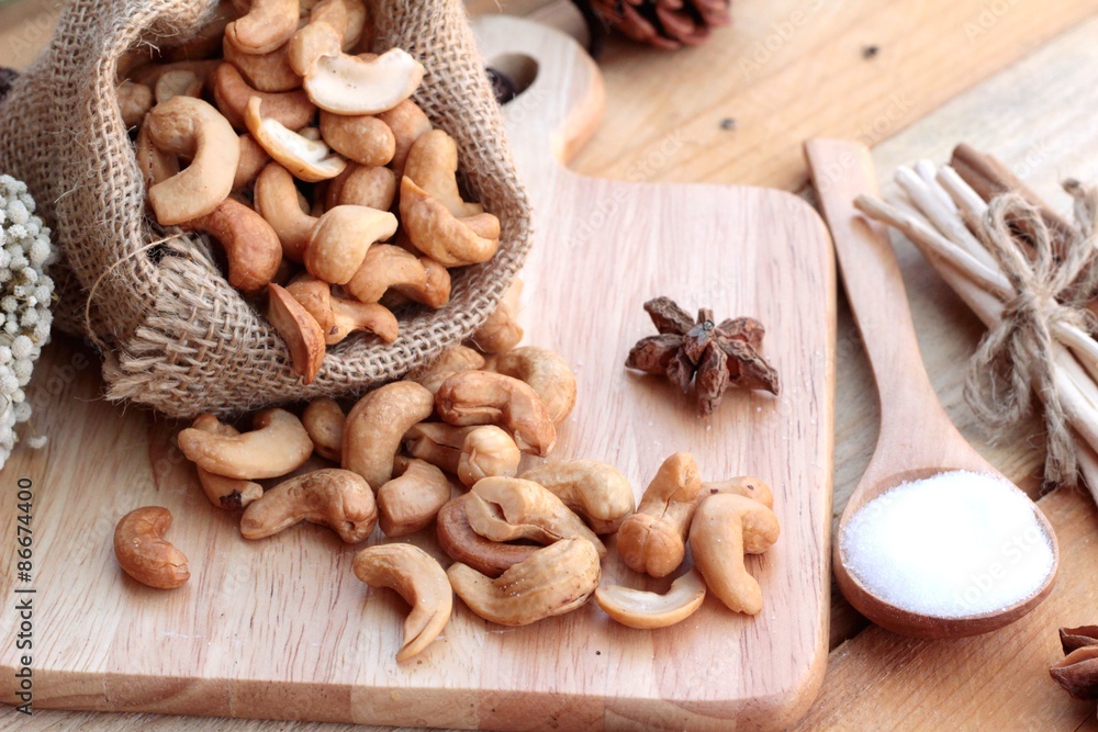 Roasted cashews nuts with natural on wood background