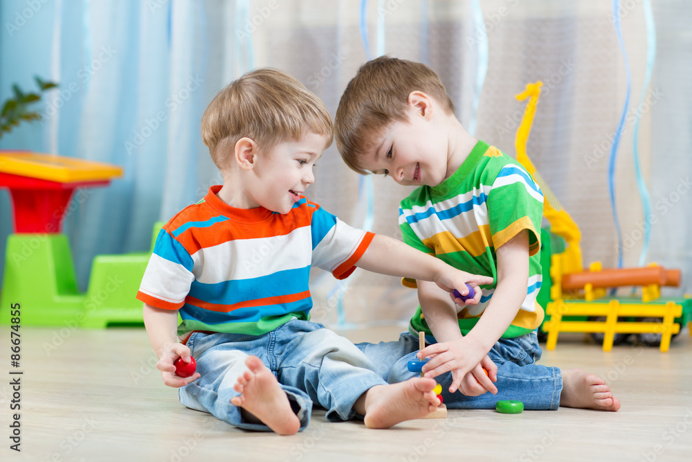 children brothers playing together in nursery or day care children brothers playing together in nursery or day care