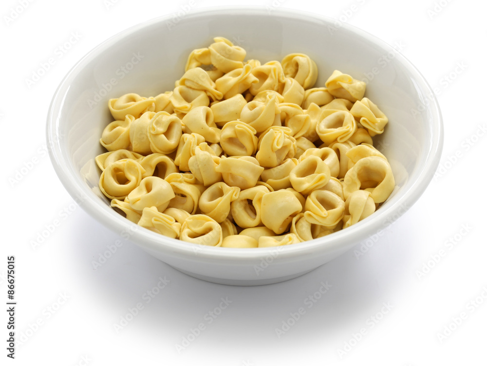 uncooked tortellini pasta in bowl isolated on white background uncooked tortellini pasta in bowl isolated on white background