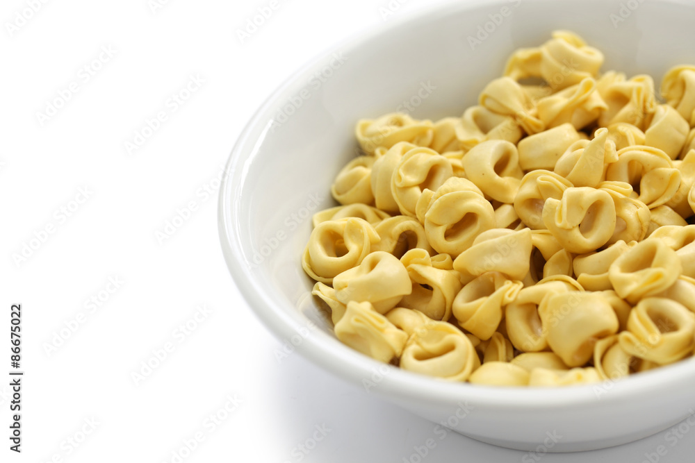 uncooked tortellini pasta in bowl isolated on white background uncooked tortellini pasta in bowl isolated on white background