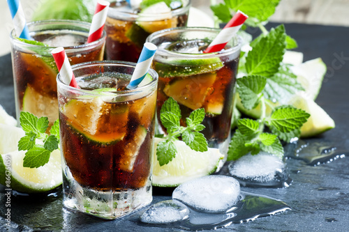 Photography Cuba Libre with lime, mint and ice in a glass, selective focus