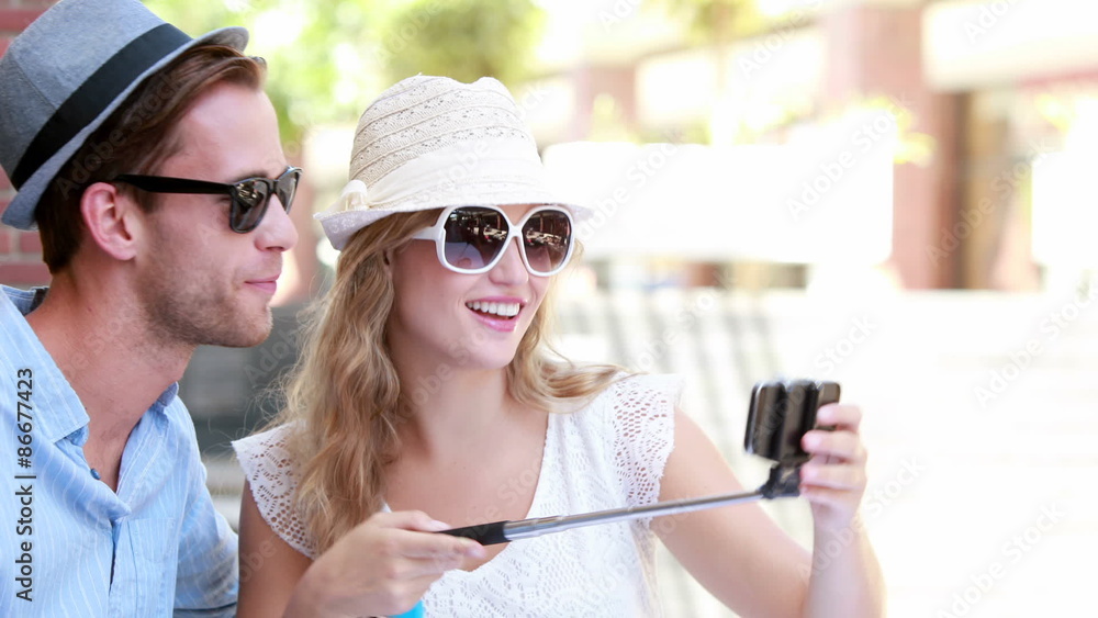 Cute couple using a selfie stick Cute couple using a selfie stick