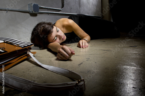 female crime victim laying on the street floor or passed out drunk photo