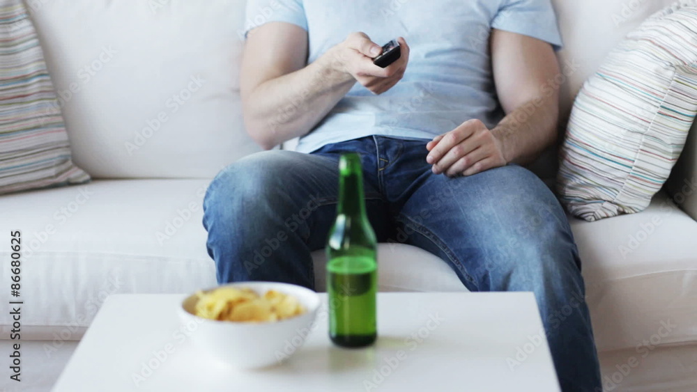 close up of man with beer and remote at home close up of man with beer and remote at home