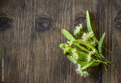 Blossoms of linden tree on wooden background
