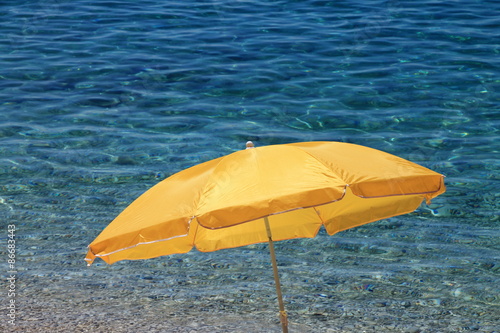 Yellow beach umbrella near the Adriatic sea   Croatia