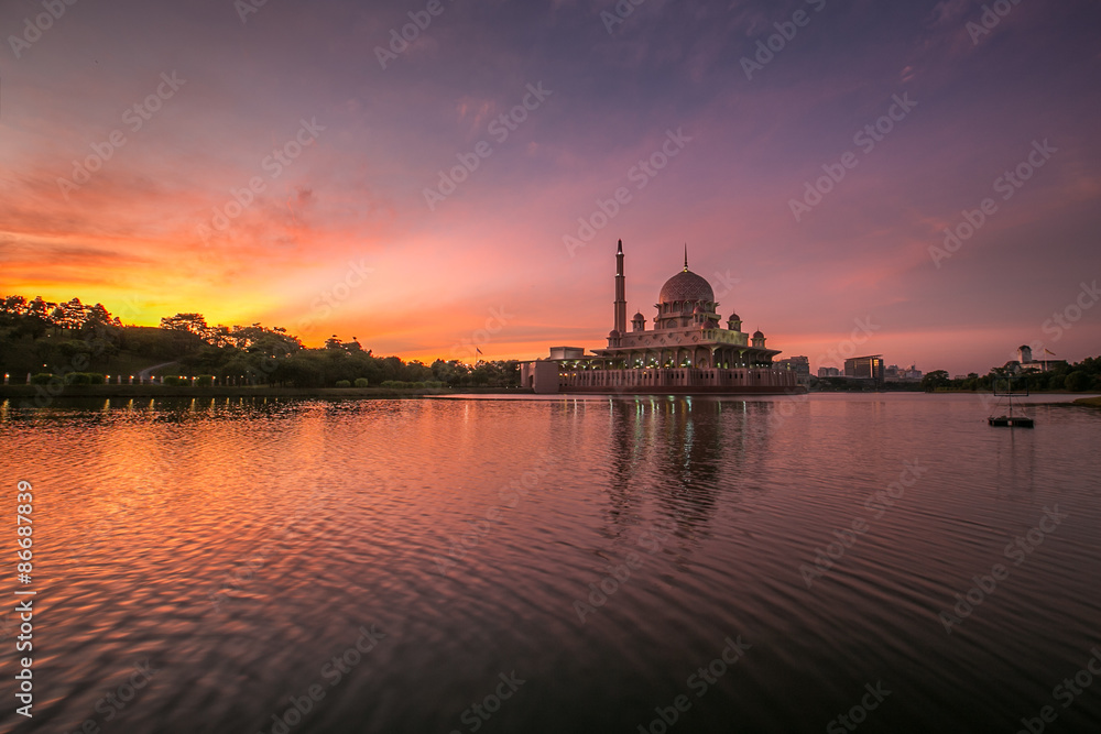 beautiful sunrise At Putra Mosque, Putrajaya Malaysia with colorful clouds and reflection on the lake surface