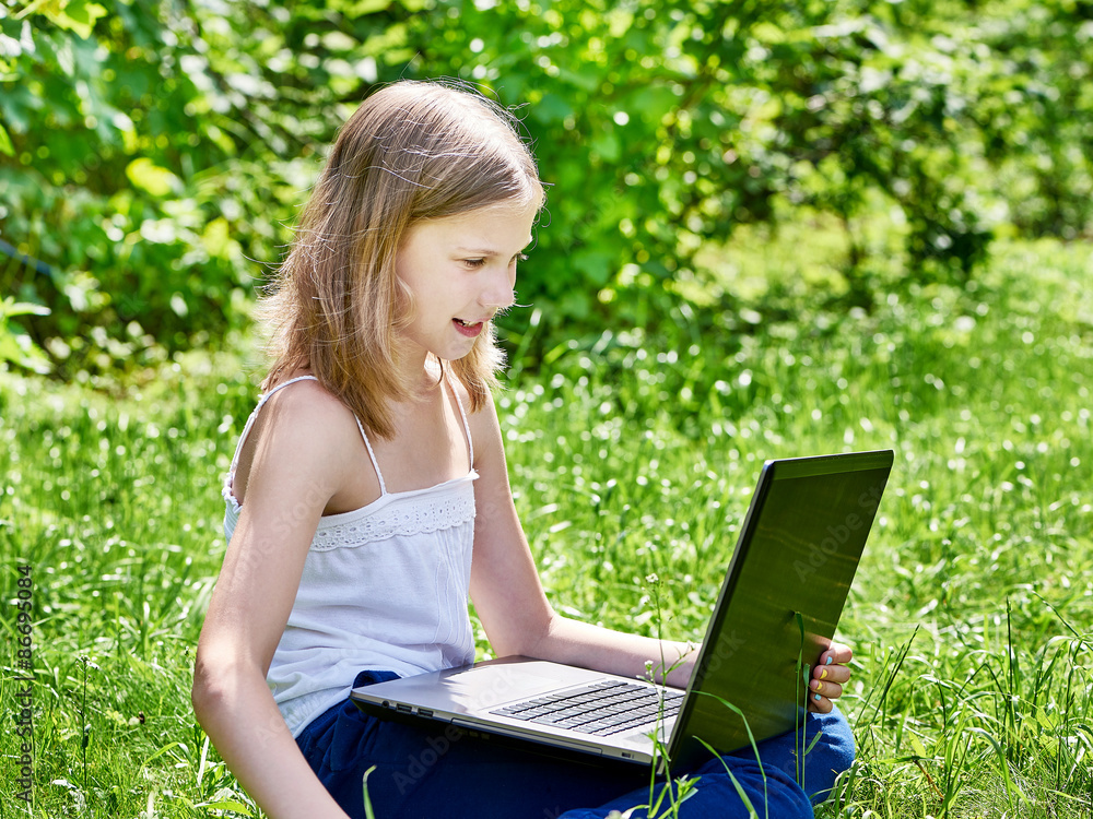 Girl using laptop on grass Girl using laptop on grass