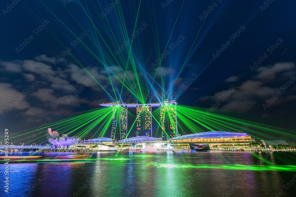 Fototapeta premium SINGAPORE, SINGAPORE - JAN 29, 2015: Marina Bay Sands hotel at night on June 29, 2015 in Singapore. Wonderful laser show, the largest light and water spectacle in Southeast Asia