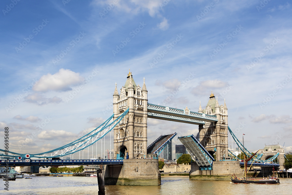 Obraz premium Tower Bridge London England raised open opening with river thames city financial district in the distance photo