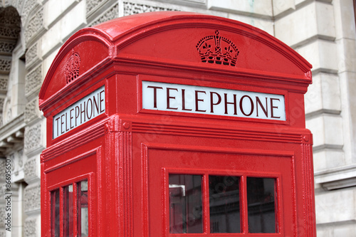 London red telephone box booth with government building in the background photo